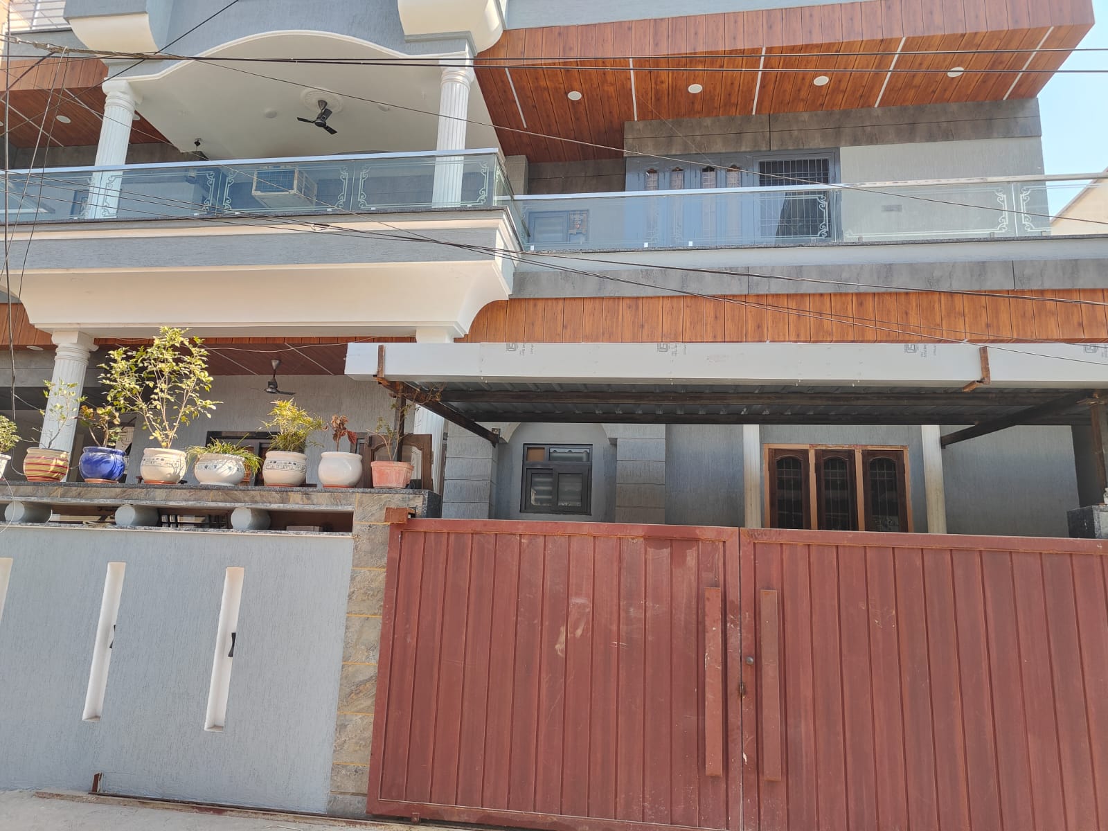 Residential exterior with glass railing and wooden ceiling